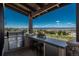 This is an outdoor kitchen with stainless steel appliances, a beverage cooler, a sink, and bar stool seating at 10805 Evergold Way, Highlands Ranch, CO 80126