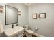 Chic powder room with a pedestal sink, framed mirror, and elegant wall sconces at 10805 Evergold Way, Highlands Ranch, CO 80126