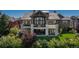 Luxury home with a stone facade, multiple balconies, and beautifully landscaped backyard at 10805 Evergold Way, Highlands Ranch, CO 80126