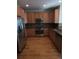 L-shaped kitchen with hardwood floors and stainless steel appliances at 8436 E 35Th Ave, Denver, CO 80238