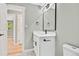 Bathroom features a sleek white vanity with modern black fixtures, a large mirror, and neutral wall paint at 2122 S Zephyr St, Lakewood, CO 80227