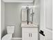 Modern powder room featuring black fixtures, a sleek mirror and unique tile flooring at 2122 S Zephyr St, Lakewood, CO 80227