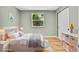 Bedroom features hardwood floors, closet space, a large window, and light-toned walls, creating a serene atmosphere at 2122 S Zephyr St, Lakewood, CO 80227