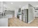 Open concept kitchen with modern appliances, white cabinets, hardwood floors, and ample counter space at 2122 S Zephyr St, Lakewood, CO 80227