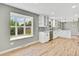 Bright kitchen featuring hardwood floors, grey backsplash and white cabinets and countertops at 2122 S Zephyr St, Lakewood, CO 80227