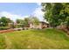 Spacious backyard with lush lawn, mature trees, a basketball court and comfortable patio area at 2849 E Cresthill Ave, Centennial, CO 80121
