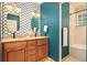 Elegant bathroom featuring double vanity, patterned wallpaper, and tiled shower at 2849 E Cresthill Ave, Centennial, CO 80121