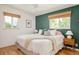 Bright primary bedroom featuring hardwood floors, a ceiling fan, and a green accent wall at 2849 E Cresthill Ave, Centennial, CO 80121