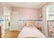 Cozy bedroom with light pink walls, floral wallpaper and a hardwood floor at 2849 E Cresthill Ave, Centennial, CO 80121