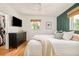 Spacious primary bedroom with hardwood floors, closet, and a green accent wall at 2849 E Cresthill Ave, Centennial, CO 80121