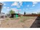Large backyard features a shed with a green door, a wooden fence, and some mature trees at 128 S Lowell Blvd, Denver, CO 80219