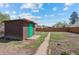 Backyard includes a shed with a green door, a wooden fence and walkway, and some foliage at 128 S Lowell Blvd, Denver, CO 80219