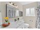 Well-lit bathroom features a shower, a white vanity, and modern fixtures at 128 S Lowell Blvd, Denver, CO 80219