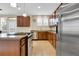 Spacious kitchen with stainless steel appliances and dark wood cabinets with bright lighting at 12831 King St, Broomfield, CO 80020