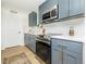 Bright kitchen with stainless steel appliances, white backsplash, and elegant gray cabinets at 6338 W 92Nd Pl, Westminster, CO 80031