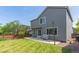 Backyard with gray siding on home, patio, lush lawn, and wood fence at 4935 Apollo Bay Dr, Highlands Ranch, CO 80130