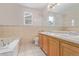 Well-lit bathroom featuring tiled walls, double sinks, a bathtub, and a toilet for everyday convenience at 4935 Apollo Bay Dr, Highlands Ranch, CO 80130