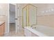 Well-lit bathroom featuring a bathtub, glass enclosed shower, and access to a bedroom at 4935 Apollo Bay Dr, Highlands Ranch, CO 80130