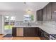 Modern kitchen showcasing granite countertops, stylish backsplash, dark cabinetry, and stainless steel appliances at 4935 Apollo Bay Dr, Highlands Ranch, CO 80130