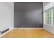 Bright living room with hardwood floors, gray accent wall, and a large window for natural light at 4935 Apollo Bay Dr, Highlands Ranch, CO 80130
