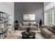 Staged living room with modern furniture, neutral tones, art, rug and large windows for natural light at 4935 Apollo Bay Dr, Highlands Ranch, CO 80130