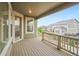Back deck with a wooden floor and railing overlooking the fenced backyard and neighboring homes at 5128 Preserve Pl, Firestone, CO 80504