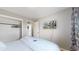 Grey bedroom with hardwood floors features an open closet, wall-mounted television, and a full bed at 1852 S Forest St, Denver, CO 80222