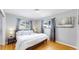 Bright bedroom featuring hardwood floors, grey walls, two windows, and a bed with white linens at 1852 S Forest St, Denver, CO 80222