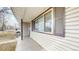 Covered front porch with dark shutters and neutral siding on a quiet tree-lined street at 1852 S Forest St, Denver, CO 80222