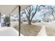 Covered front porch and spacious front yard featuring a mature tree and view of the quiet neighborhood at 1852 S Forest St, Denver, CO 80222