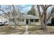 Charming single-story home with beige siding, blue front door, and mature trees in the front yard at 1852 S Forest St, Denver, CO 80222