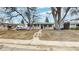 Charming single-story home with beige siding, blue door, and landscaped front yard with mature trees at 1852 S Forest St, Denver, CO 80222