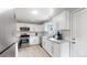 Bright kitchen features stainless appliances, white cabinets, and stone countertops at 1852 S Forest St, Denver, CO 80222