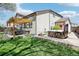 Landscaped backyard featuring a pergola, dining area, hot tub, and lawn at 10889 Alcott Ct, Denver, CO 80234