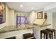 Finished basement bar with a marble countertop and stocked bar with display shelves at 10889 Alcott Ct, Denver, CO 80234