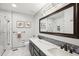 Modern bathroom with marble countertop, blue backsplash, and a framed mirror at 10889 Alcott Ct, Denver, CO 80234