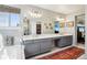 Bright bathroom with double vanity, marble counters, and a large mirror at 10889 Alcott Ct, Denver, CO 80234