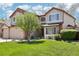 Charming two-story home with a well-manicured lawn and mature tree, complemented by a two car garage at 10889 Alcott Ct, Denver, CO 80234