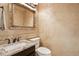 Elegant half bathroom offering decorative wall texture, decorative mirror, and stone countertop at 10889 Alcott Ct, Denver, CO 80234