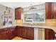 A well lit kitchen offers cherry cabinets, granite countertops, and stainless steel dishwasher at 10889 Alcott Ct, Denver, CO 80234