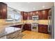Modern kitchen with stainless steel appliances, granite countertops, and custom cabinetry at 10889 Alcott Ct, Denver, CO 80234