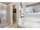 Bright bathroom with glass shower, soaking tub, and white tile at 10889 Alcott Ct, Denver, CO 80234