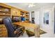 Spacious office area with custom wood cabinets and a comfortable chair at 10889 Alcott Ct, Denver, CO 80234