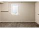 Finished basement area with neutral paint, carpet, a window, and a white door at 654 S Shoshone St, Denver, CO 80223