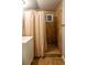 Tiled bathroom featuring a shower stall with a neutral-toned curtain, window, and vanity at 654 S Shoshone St, Denver, CO 80223