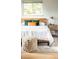 Bright bedroom features a comfortable bed, accent pillows, a side table, a window, and a braided pouf at 654 S Shoshone St, Denver, CO 80223