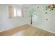 Bright bedroom with hardwood floors, a window, and fun wall decals for a whimsical touch at 654 S Shoshone St, Denver, CO 80223