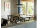 Dining area with a wooden table, designer lighting, and a view to the outside at 654 S Shoshone St, Denver, CO 80223