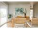 Bright dining room with a wooden table, woven chairs, a glass door, and green artwork on the wall at 654 S Shoshone St, Denver, CO 80223