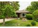 Quaint brick home with mature trees, landscaped lawn, and a cozy front porch at 654 S Shoshone St, Denver, CO 80223
